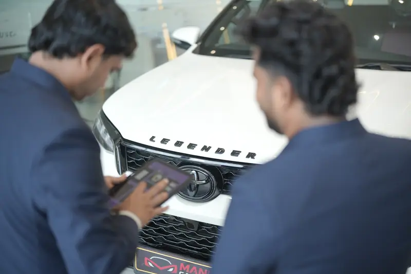 Manu's Car World specialists assessing a vehicle